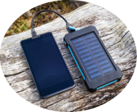 Smartphone charging with pink power bank with solar battery on wood background, selective focus and soft focus